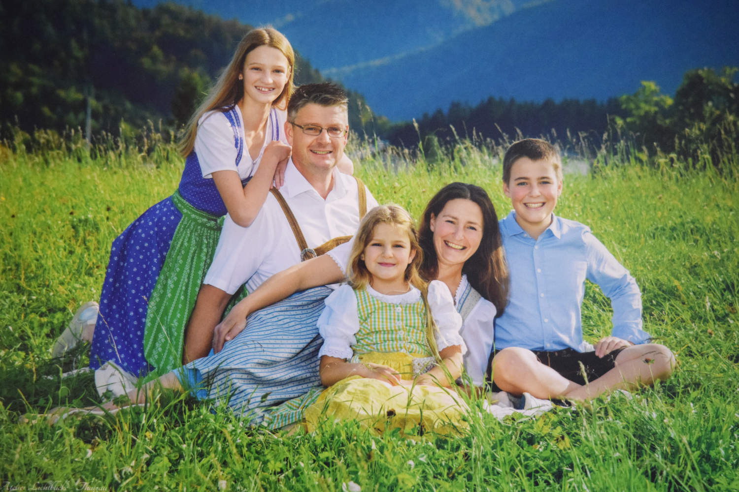 Die Familie Schmitzberger sitzt im Gras